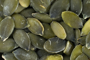 Green pumpkin seeds closeup background.