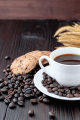 Coffee cup and coffee beans on wooden background