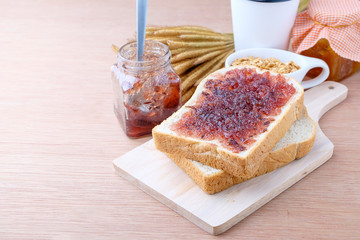 Bread with jam grape on wood background