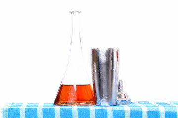 glass flask or bottle with alcohol and metallic opened shaker