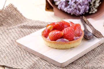 Tart with fresh strawberry on wooden background,