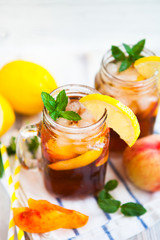 Homemade lemonade with ripe  peaches and fresh mint. Fresh peach ice tea on white wood table. Copy space background.