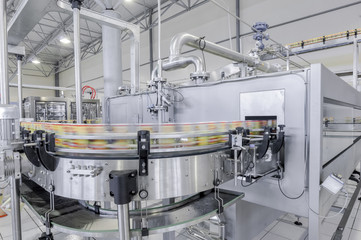 conveyor belt in motion at production and bottling of drinks in tin cans. production and bottling of drinks in tin cans
