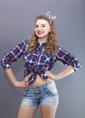 
Sexual  girl in US stile  stand  in front of gray background and smile
