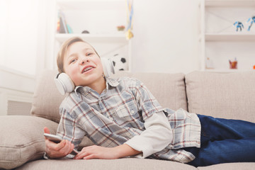 Fototapeta premium Teenage boy enjoying music in headphones at home