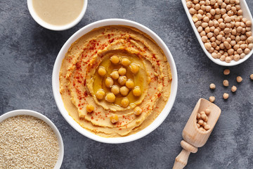 Hummus homemade middle eastern arab dip paste flat lay with paprika, tahini, sesame, and olive oil, healthy diet natural vegetarian nutrition snack protein food. Traditional mediterranean appetizer