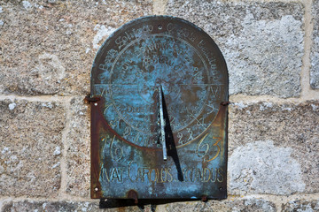 Very old sundial hangs on the stone wall of a church in the village of Throwleigh. On the clock is written: Vivat Carolus Secundus, 1663. West Devon. England