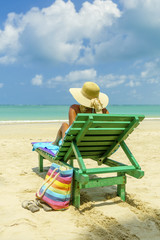 Fototapeta na wymiar Woman on a deck chair at the beach