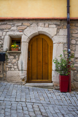 Fototapeta na wymiar Old Vintage Cobblestone Alley Street Door Entrance Wooden Design Colors Italy Flowers Tiny House Cute