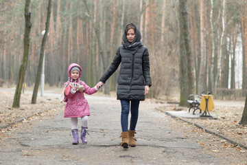 Mom and daughter are walking around the park in the hand