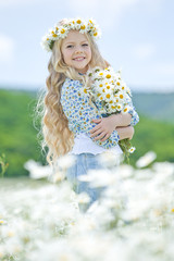 Beautiful little girl on nature with flowers 