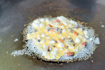 Fried mussel with egg batter in the pan delicious food of Thailand