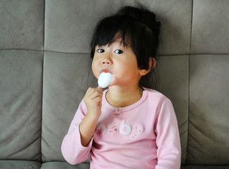 Sick little girl giving medicine by herself