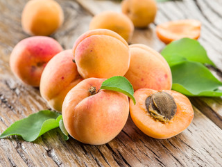 Apricots and its cross-section on the old wooden table.