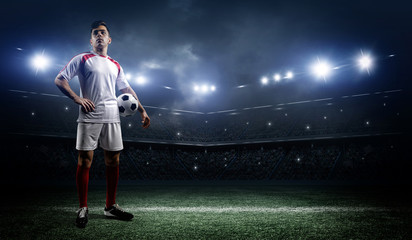 Football player with ball on field of stadium - obrazy, fototapety, plakaty