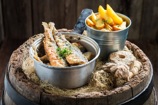 Fresh herring fish and chips with herbs and salt