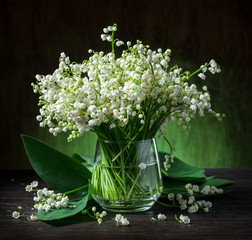 Lily of the valley bouquet on the wooden table.