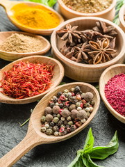 Assortment of colorful spices in the wooden spoons.