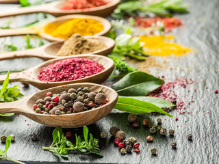 Assortment of colorful spices in the wooden spoons.