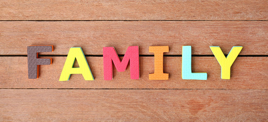 Alphabet letters "FAMILY" on wood plank. Education concept.