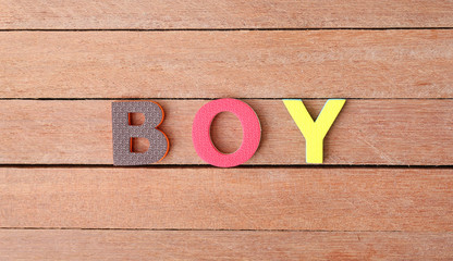 Alphabet letters "BOY" on wood plank. Education concept.