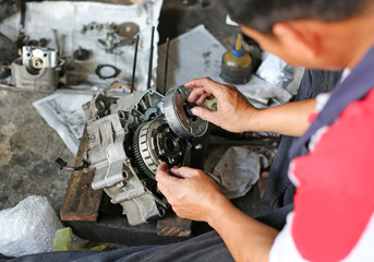 a pair of technician hand fixing the motorcycle