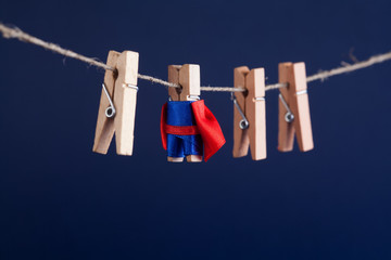 Powerful super hero conceptual photo with superstar clothespin character in blue suit red cape....