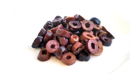 Heap of sliced olives on white