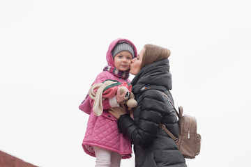 Mom and daughter kissing on nature in the spring