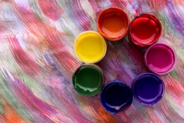 Abstract flower made of colorful gouache paint containers colored background