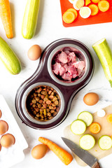 petfood set with vegetables and meat on kitchen table background top view