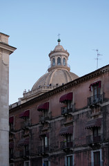 Obraz premium For the beautiful facades of buildings can be seen a majestic dome of Church Badia Saint Agata. Catania. Sicily. Italy