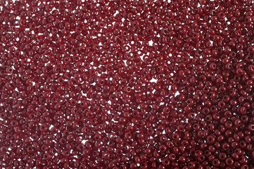 Crimson-red glass beads background - closeup beads texture