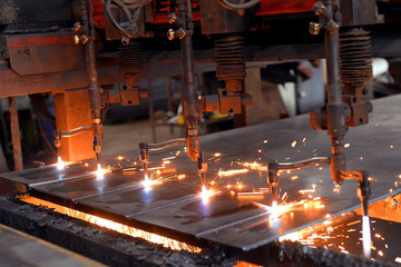 Oxygen torch cuts steel sheet. CNC gas cutting machine. Bright sheaf of sparks of molten metal
