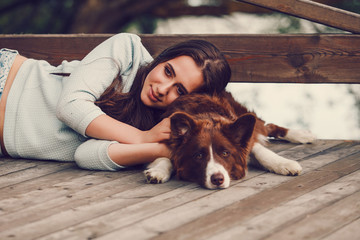 Young woman lying with her border collie dog - obrazy, fototapety, plakaty