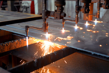 Oxygen torch cuts steel sheet. CNC gas cutting machine. Bright sheaf of sparks of molten metal