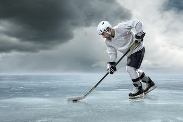 Ice hockey player on the ice in mountains