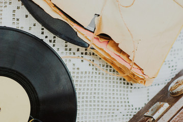 Stack of scratched dusty old vinyl records tied with rope on white background