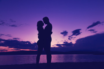 Fototapeta na wymiar Couple enjoying on the beach in sunset / sunrise time.