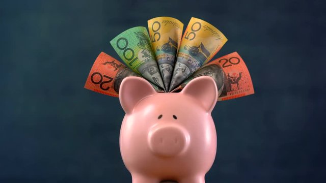Australian currency with pink piggy bank