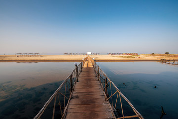 Wooded bridge in the port between sunrise.