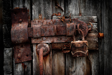 Old rusty padlock on wooden door