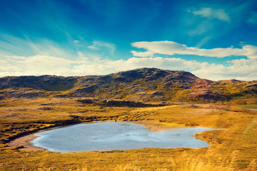 Mountain landscape. Rocky shore of mountain lake. Beautiful nature Norway. Nordkapp