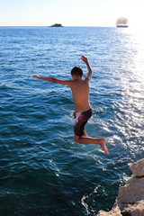 Kind springt von Klippe ins Meer