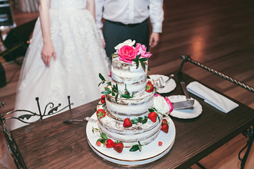 Wedding cake decorated with roses and strawberry