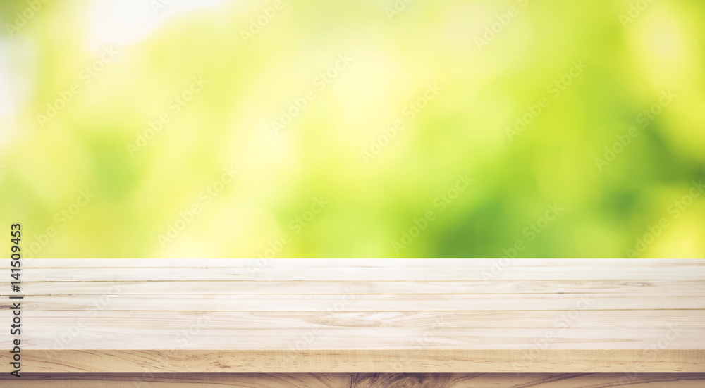 Wall mural empty wood table top on blur abstract green garden in the morning.for montage product display or key