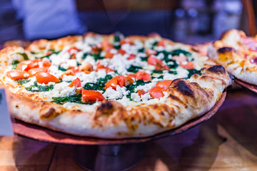 Feta cheese pizza macro closeup with tomatoes and spinach