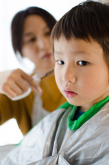 ママに髪の毛を切ってもらう男の子