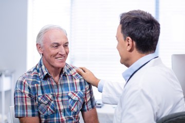 Doctor consoling senior man
