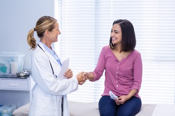 Obraz premium Female doctor shaking hands with patient